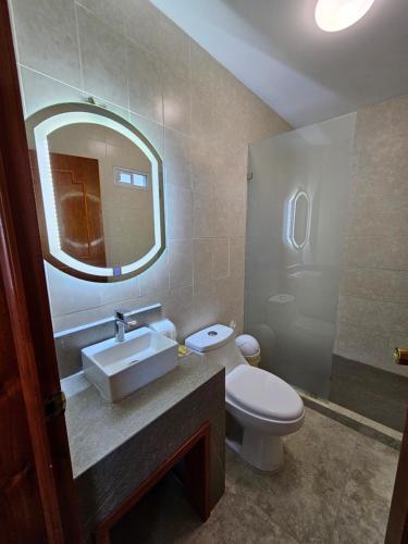 a bathroom with a sink and a toilet and a mirror at Hotel lito in Nuevo Vallarta 