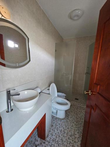 a bathroom with a sink and a toilet and a mirror at Hotel lito in Nuevo Vallarta 