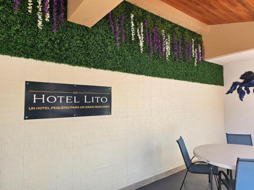 a restaurant with a table and purple flowers on the wall at Hotel lito in Nuevo Vallarta 
