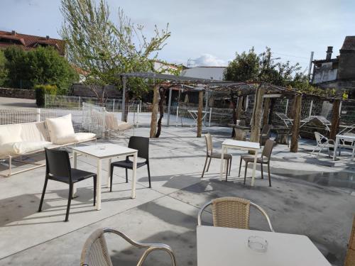 a patio with tables and chairs and a couch at Albergue playa de sabaris in Sabaris