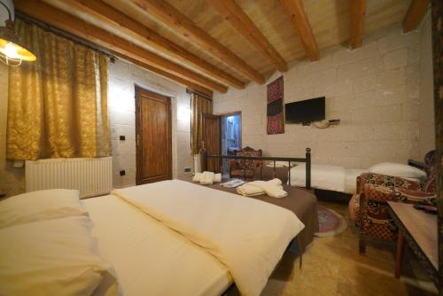 ein Schlafzimmer mit zwei Betten und einem Fernseher in einem Zimmer in der Unterkunft View Cave Hotel in Goreme