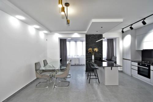 a kitchen and dining room with a glass table and chairs at Luxury Apartment, 2 bedrooms and 1 living room in Avan in Yerevan