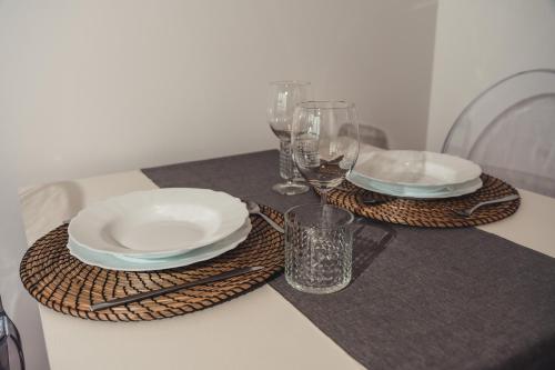 a table with plates and wine glasses on a table at Lo Spettacolo in Macerata