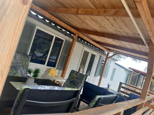 a screened porch with a wooden pergola at DM mobile home in Jezera