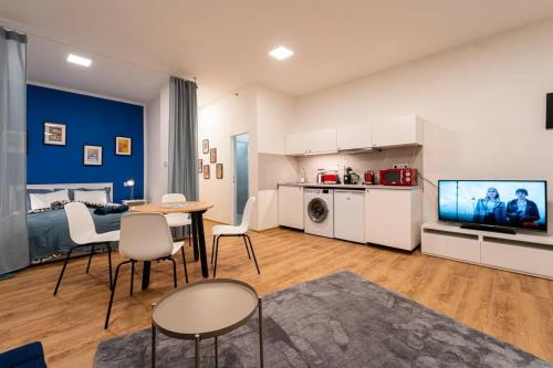 uma sala de estar com uma cama, uma mesa e cadeiras em Sauna Apartment - Brno(x) Cejl em Brno