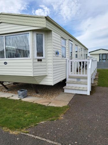 a small white caravan with a porch and a porch at Beautiful Caravan in Ingoldmells