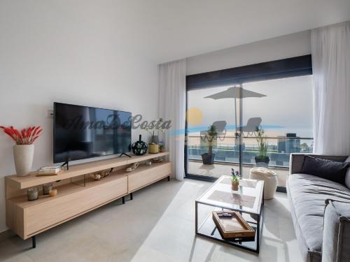 sala de estar con TV grande y sofá en CASCADA del MAR I - GRAN ALACANT, en Gran Alacant