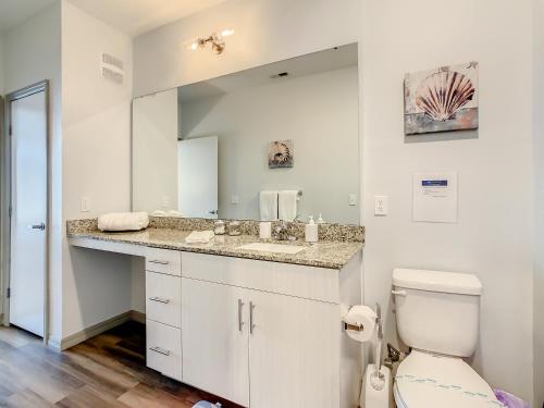 a bathroom with a sink and a toilet and a mirror at Spacious Apartment Near Disney in Kissimmee
