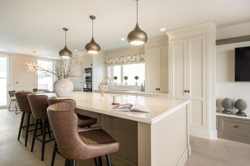 a kitchen with a large island with bar stools at Atlantic View in Portstewart