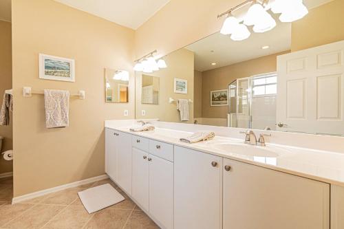 un bagno con un lavandino e un grande specchio di Flamingo Fairways II a Lely Resort