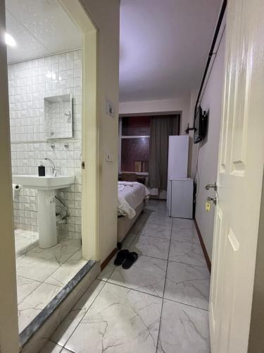 uma casa de banho com um lavatório e uma casa de banho com uma cama em Yildiz Hotel em Istambul
