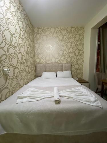 um roupão branco deitado numa cama num quarto em Yildiz Hotel em Istambul