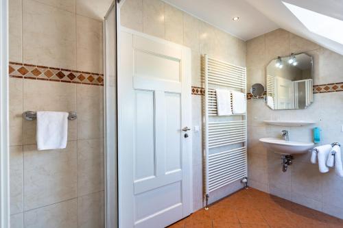 a bathroom with a white door and a sink at Ferienwohnung Christiane in der Villa zum Kronprinzen direkt gegenüber der SaarowTherme in Bad Saarow