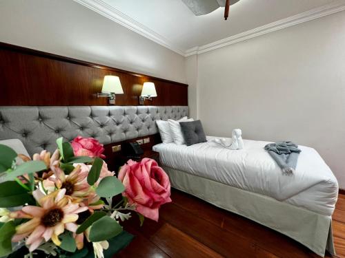 a bedroom with a bed and a couch and flowers at Dakani Hotel Boutique NEW in Quito