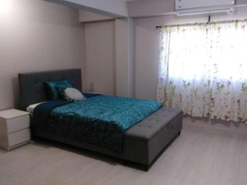 1 dormitorio con 1 cama y una ventana con cortinas en Miss Pea Apartments en Crown Point