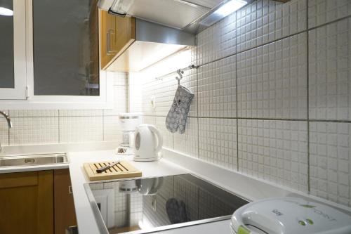 un bagno piastrellato bianco con lavandino e servizi igienici di Elegant central apartment a Heraklion