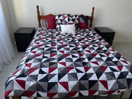 a quilt on a bed in a bedroom at Miss Pea Apartments in Crown Point
