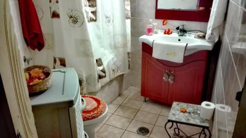 een badkamer met een rode wastafel en een toilet bij ARKASA KARPATHOS SEAFRONT PARADISOS in Karpathos