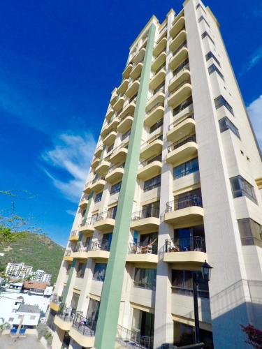 a tall apartment building with a blue sky in the background at El Peñon del Rodadero Apartamento Playa Rodadero 8 in Puerto de Gaira
