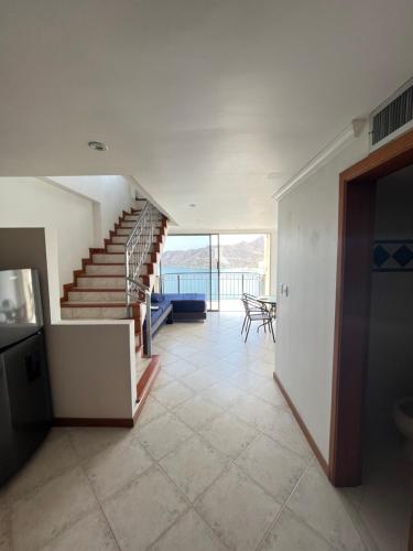 a living room with a staircase and a table at El Peñon del Rodadero Apartamento Playa Rodadero 8 in Puerto de Gaira
