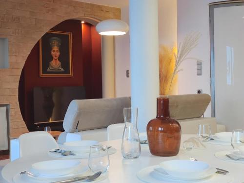 a table with white plates and a vase on it at Apartament Nefretete in Łódź