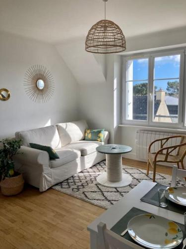 un salon avec un canapé blanc et une table dans l'établissement Le Citronnier, à Fouesnant