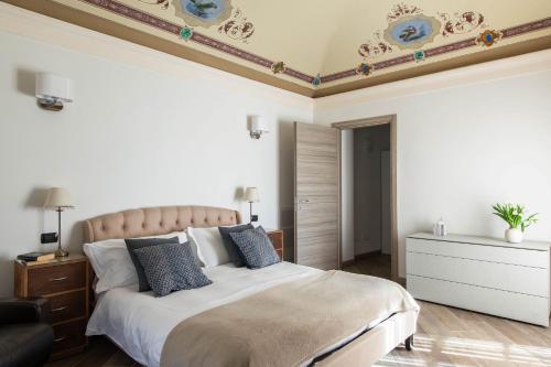 a bedroom with a large bed with blue pillows at Casa Castellino by LoveComo in Menaggio