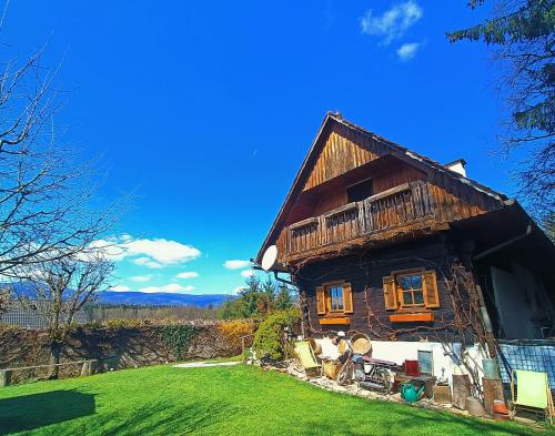 a wooden house with a green lawn in front of it at Pension Treissmann in Pichling bei Stainz