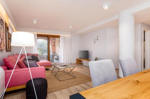a living room with a pink couch and chairs at Lola's Luxury Apartments in Liapades