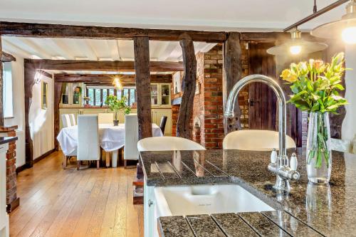 Beautiful 10 Bed Oak beamed Country House في Tibenham: مطبخ مع حوض وغرفة طعام