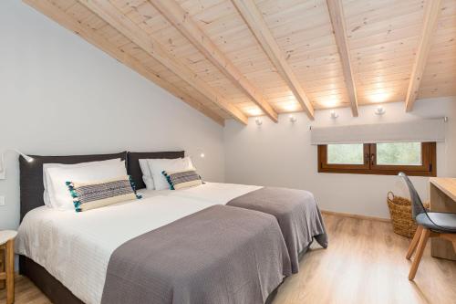 a bedroom with a large bed and a wooden ceiling at Lola's Luxury Apartments in Liapades