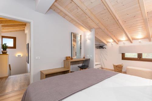 a bedroom with a white bed and a desk at Lola's Luxury Apartments in Liapades