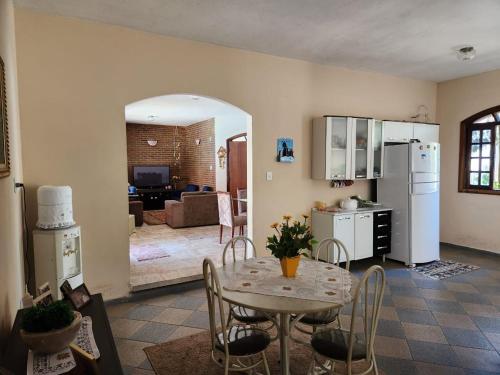 een keuken en een woonkamer met een tafel en stoelen bij Casa Inteira Família próxima ao Santuário Nacional in Aparecida
