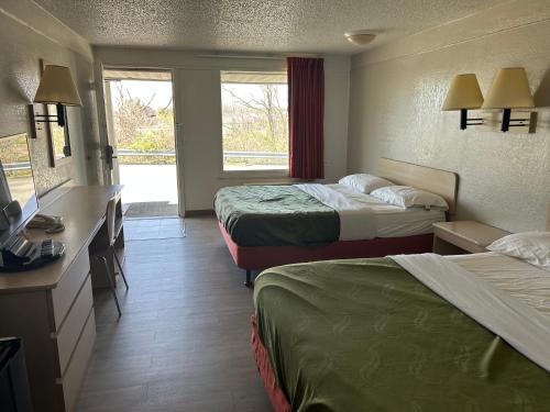 a hotel room with two beds and a television at Rodeway Inn in Washington