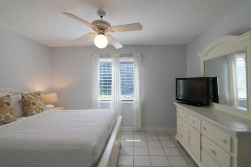 Un dormitorio con una cama y un ventilador de techo. en Madelyn's Oceanview, en Tybee Island