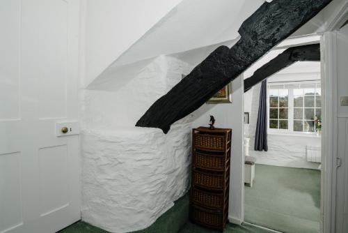 Zimmer mit einer weißen Steinmauer und einem Fenster in der Unterkunft Shilla Mill - Just off the Beach in Polzeath