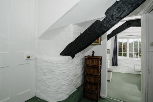 a room with a white stone wall and a window at Shilla Mill - Just off the Beach in Polzeath