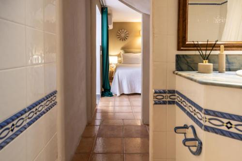 a hallway with a bathroom with a bed and a mirror at Valley Club Ibiza - Boutique Agroturismo in Sant Joan de Labritja
