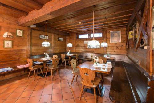 a restaurant with wooden walls and tables and chairs at Hotel Casa Alpina - Alpin Haus in Selva di Val Gardena