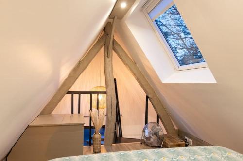 Pokój na poddaszu z oknem i schodami w obiekcie Le Puits Jaune - Gîte Nature et Spa w mieście Saint-Denis-le-Thiboult