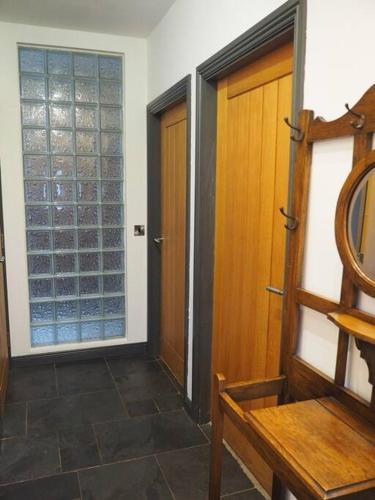 a hallway with two wooden doors and a mirror at Fern Lodge Angus, Kirriemuir in Angus