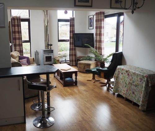 a living room with a table and chairs and a couch at Fern Lodge Angus, Kirriemuir in Angus