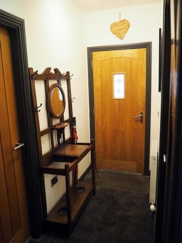 a hallway with a mirror and a wooden door at Fern Lodge Angus, Kirriemuir in Angus