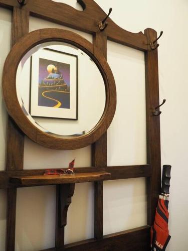 a mirror on a wall with a wooden shelf at Fern Lodge Angus, Kirriemuir in Angus