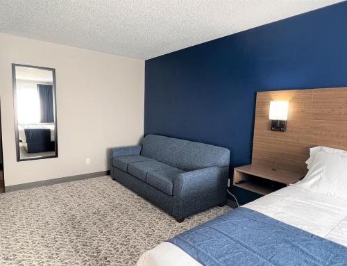 a bedroom with a bed and a chair in it at Hilltop Inn & Suites in Grove