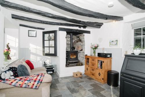a living room with a couch and a fireplace at Shilla Mill - Just off the Beach in Polzeath