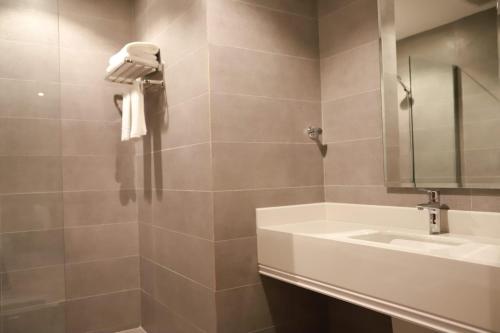 y baño con lavabo y espejo. en Tulip View Hotel en Khamis Mushayt