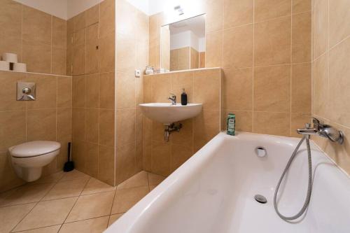 La salle de bains est pourvue d'une baignoire, d'un lavabo et de toilettes. dans l'établissement Astronaut Studio - Brno Centrum, à Brno
