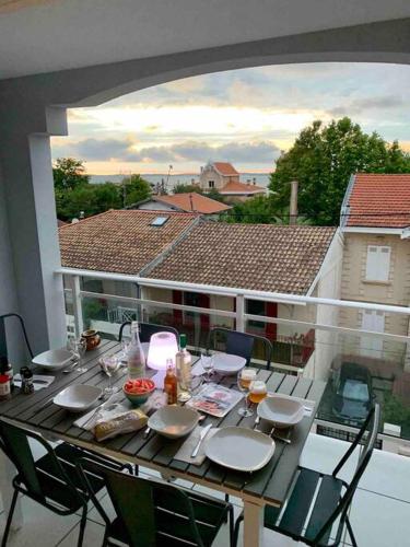 a table on a balcony with a view of a house at Nice Appartment in Arcachon, near the beach in Arcachon
