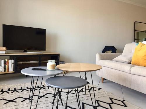 a living room with two tables and a couch at Nice Appartment in Arcachon, near the beach in Arcachon
